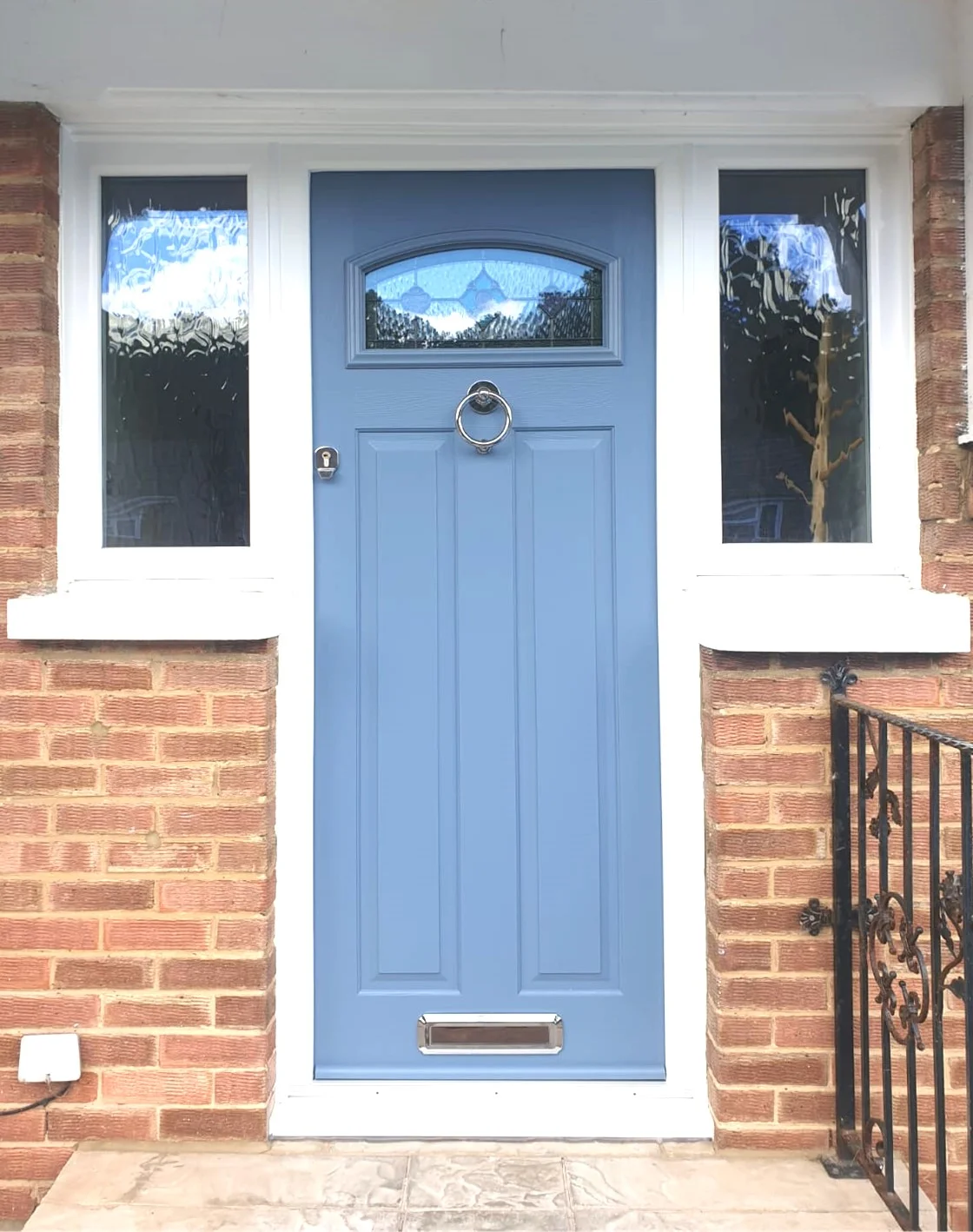 Blue front door with silver finishings including door knocker and letterbox.